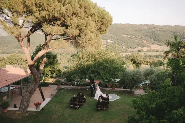 A wide view across Terzo di Danciano to Anthony and Isabella’s garden ceremony.
